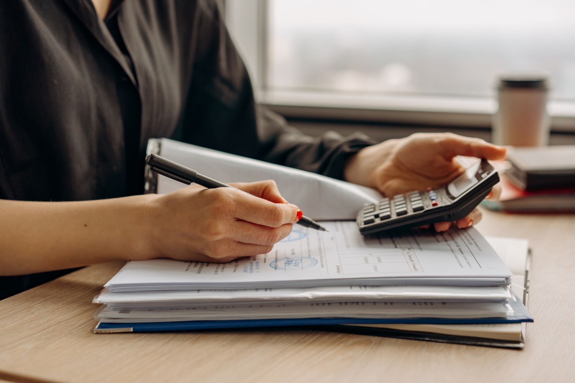 Persona calculando con una calculadora sobre documentos laborales